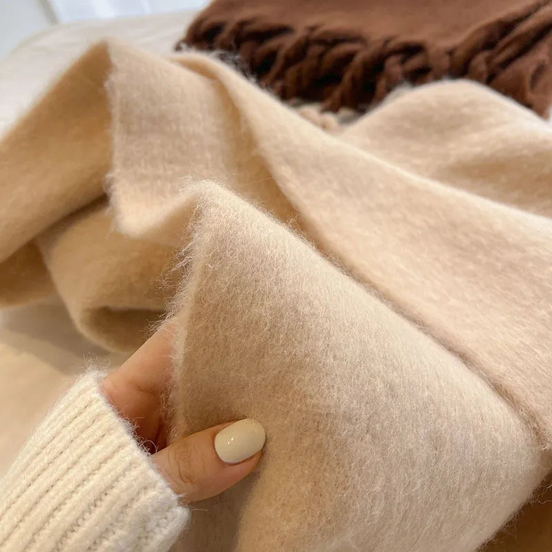 woman feels scarves to show the thickness and soft texture of the scarves