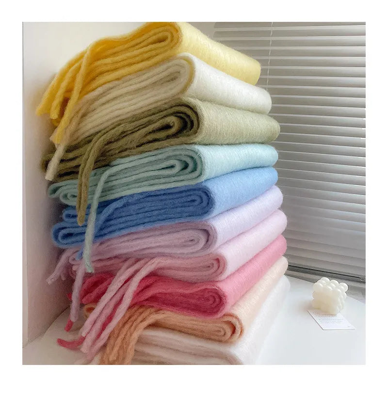 An array of beautiful cashmere scarves folded and stacked together on a windowsil