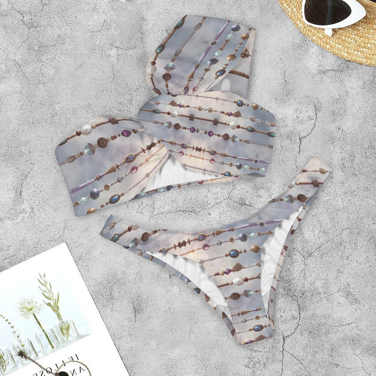 Air Goddess patterned bikini top and bottom on a textured surface with sunglasses