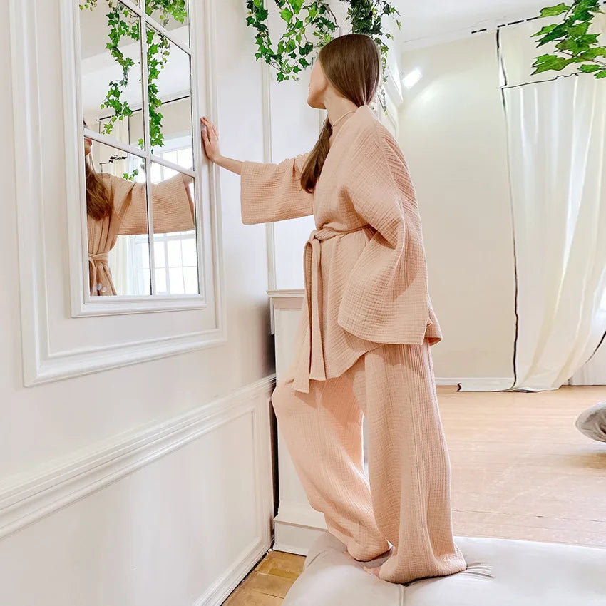 Model wearing almond tan Ira Kimono and Pants set. Breathable cotton lounge set with matching open-front kimono robe, waist sash, and full-length relaxed-fit pants. Cozy fashion perfect for sleep, loungewear, or resort wear.