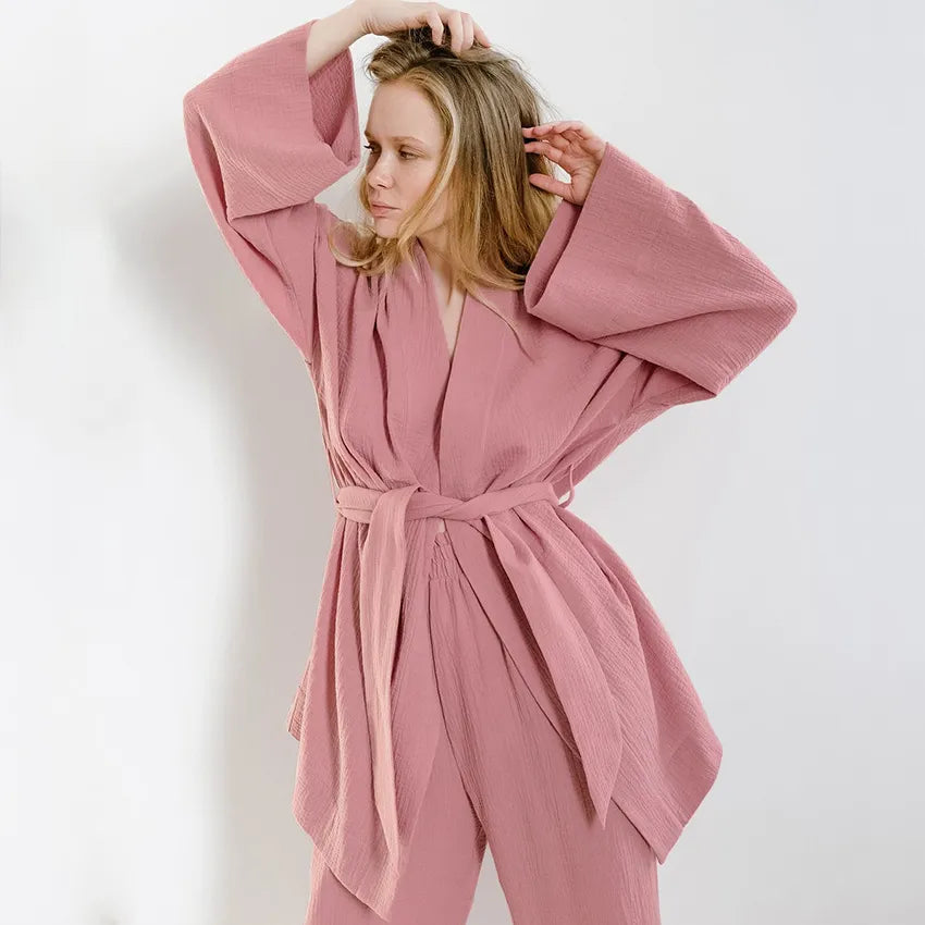Model wearing dusty pink Ira Kimono and Pants set. Breathable cotton lounge set with matching open-front kimono robe, waist sash, and full-length relaxed-fit pants. Cozy fashion perfect for sleep, loungewear, or resort wear.