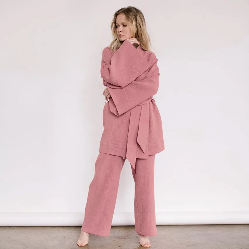 Model wearing dusty pink Ira Kimono and Pants set. Breathable cotton lounge set with matching open-front kimono robe, waist sash, and full-length relaxed-fit pants. Cozy fashion perfect for sleep, loungewear, or resort wear.