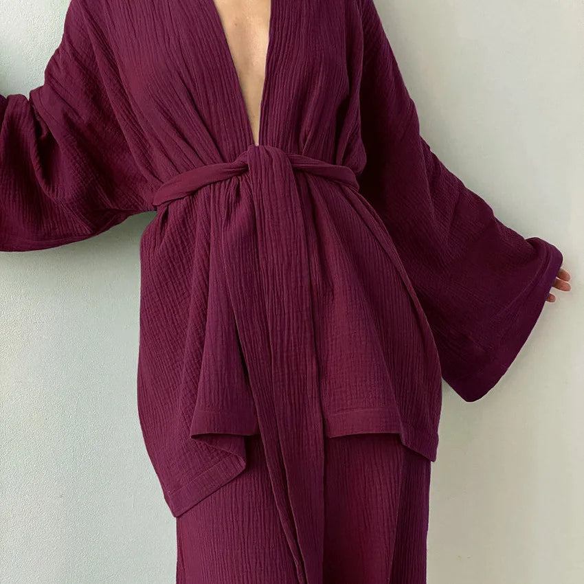Model wearing plum Ira Kimono and Pants set. Breathable cotton lounge set with matching open-front kimono robe, waist sash, and full-length relaxed-fit pants. Cozy fashion perfect for sleep, loungewear, or resort wear.