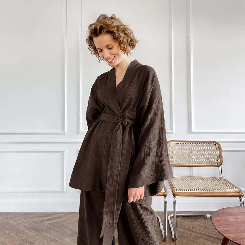 Model smiling in brown Ira Kimono and Pants set. Breathable cotton lounge set with matching open-front kimono robe, waist sash, and full-length relaxed-fit pants. Cozy fashion perfect for sleep, loungewear, or resort wear.