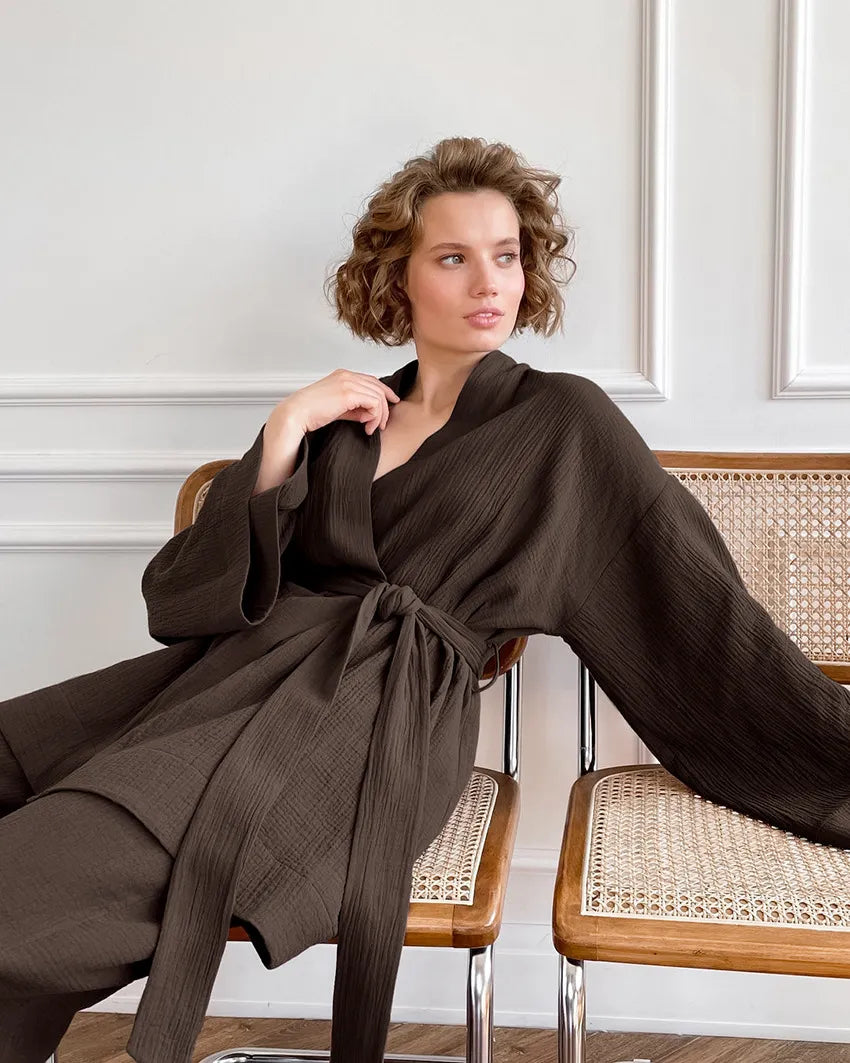 Model lounging in brown Ira Kimono and Pants set. Breathable cotton lounge set with matching open-front kimono robe, waist sash, and full-length relaxed-fit pants. Cozy fashion perfect for sleep, loungewear, or resort wear.