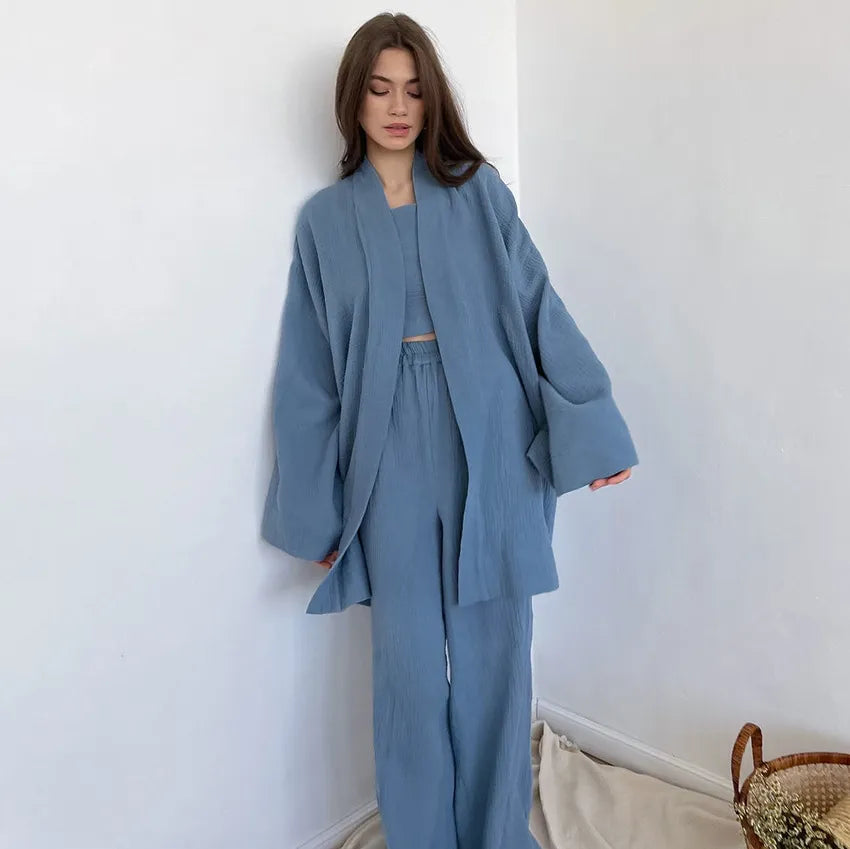 Model wearing blue Ira Kimono and Pants set. Breathable cotton lounge set with matching open-front kimono robe, waist sash, and full-length relaxed-fit pants. Cozy fashion perfect for sleep, loungewear, or resort wear.