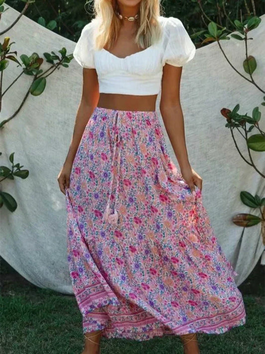 Amelie Boho Maxi Skirt from Shop The Kei - flowing pink floral maxi skirt with elastic waistband and ruffled hem, made of natural fibers. Pairs well with white lace tops and puff sleeves.