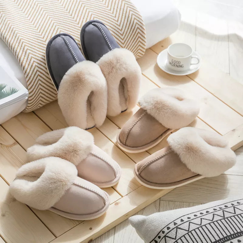 three pairs of faux fur slippers with a plush interior, displayed on a wooden surface, with a cup of coffee and a book in the background.