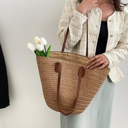 Natural tan color straw bag with tan lining, inner pocket, and brown faux leather straps
