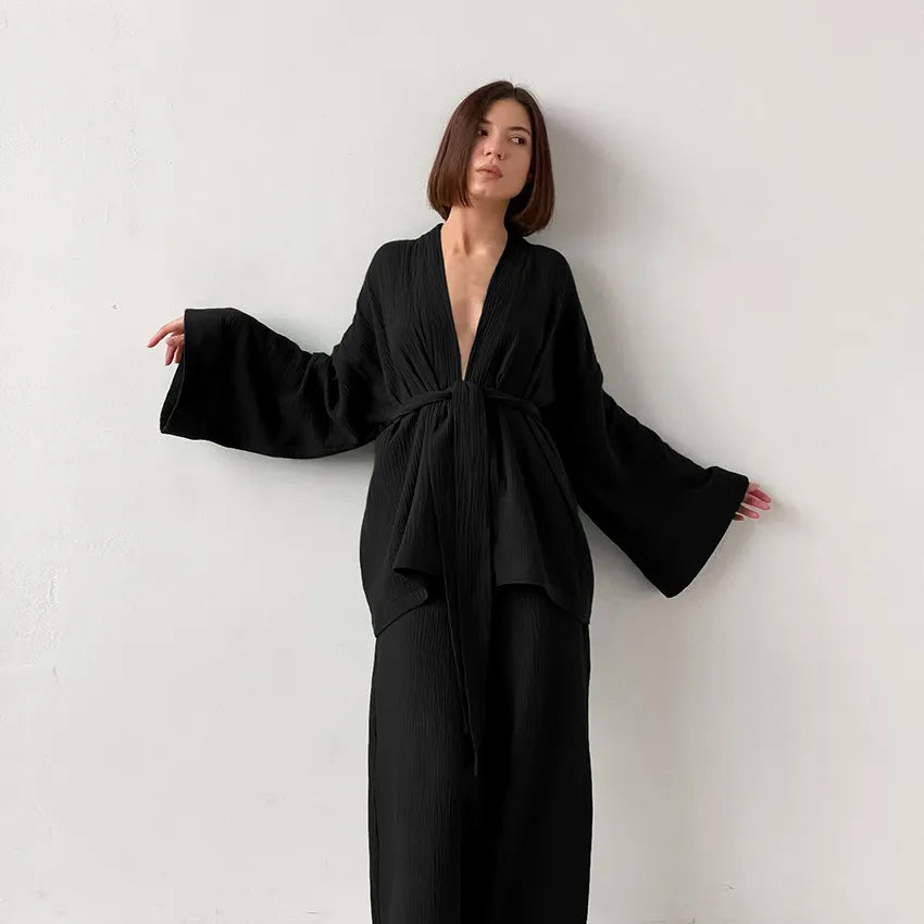 Model wearing black Ira Kimono and Pants set. Breathable cotton lounge set with matching open-front kimono robe, waist sash, and full-length relaxed-fit pants. Cozy fashion perfect for sleep, loungewear, or resort wear.