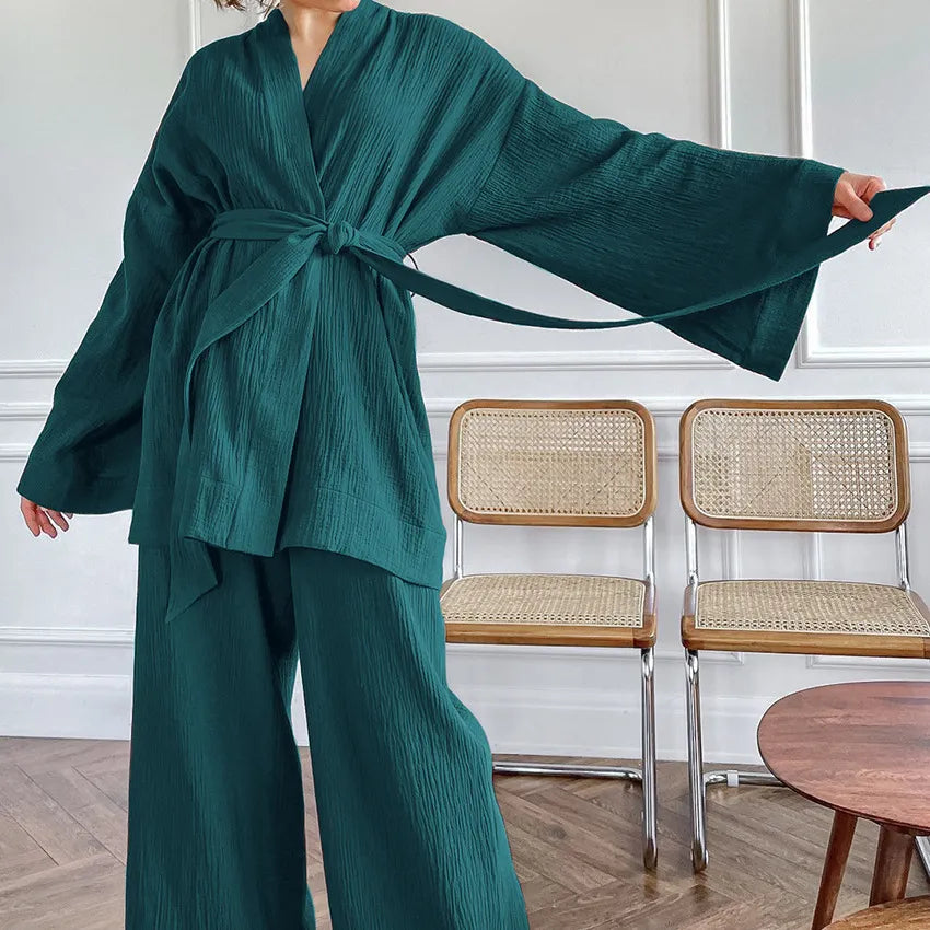 Model lounging in dark teal Ira Kimono and Pants set. Breathable cotton lounge set with matching open-front kimono robe, waist sash, and full-length relaxed-fit pants. Cozy fashion perfect for sleep, loungewear, or resort wear.