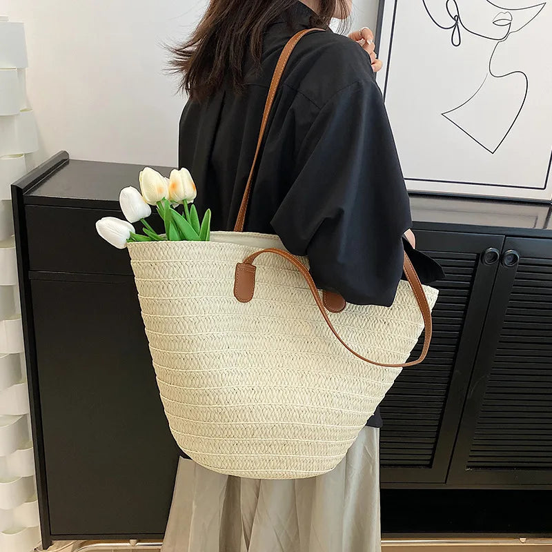 Natural ivory color straw bag with tan lining, inner pocket, and brown faux leather straps