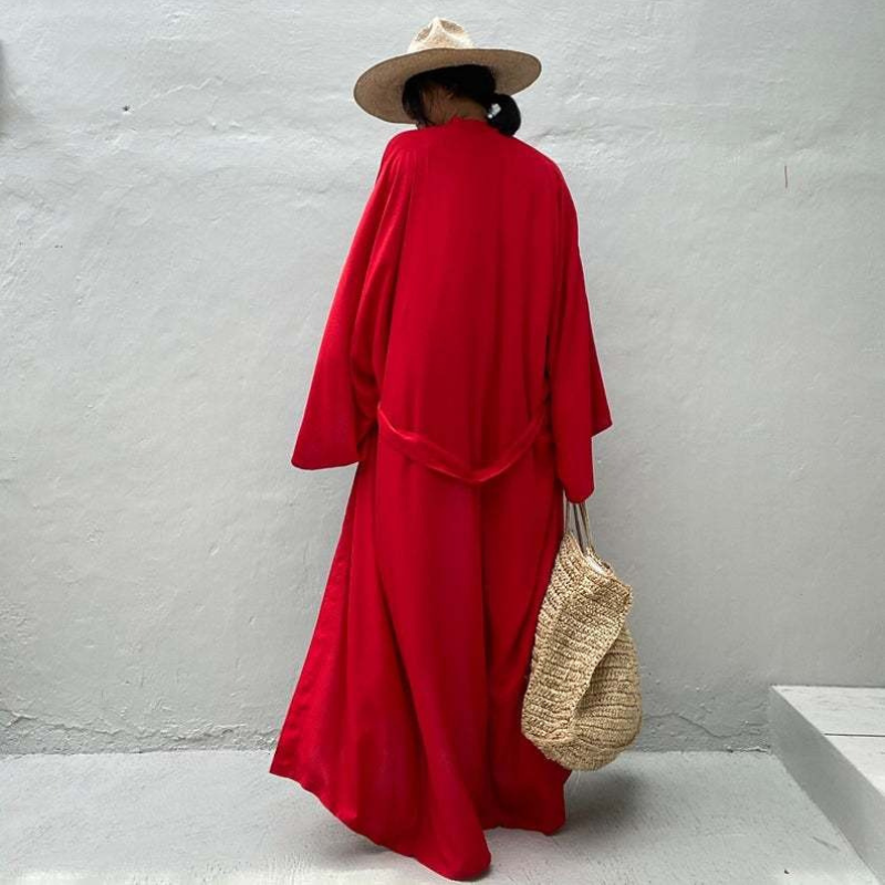 Back view of model wearing the red Sole Kimono from Shop the Kei shown with a straw hat and beach tote. A Bohemian-style ankle-length beach cover-up kimono with wide sleeves and matching waist sash, perfect for vacation, poolside, or post-swim lounging.