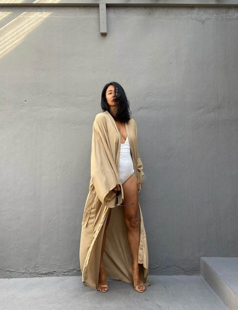 Front view of model wearing the Sand Sole Kimono from Shop the Kei with a white one piece swimsuit and gold heels. A Bohemian-style ankle-length beach cover-up kimono with wide sleeves and matching waist sash, perfect for vacation, poolside, or post-swim lounging.