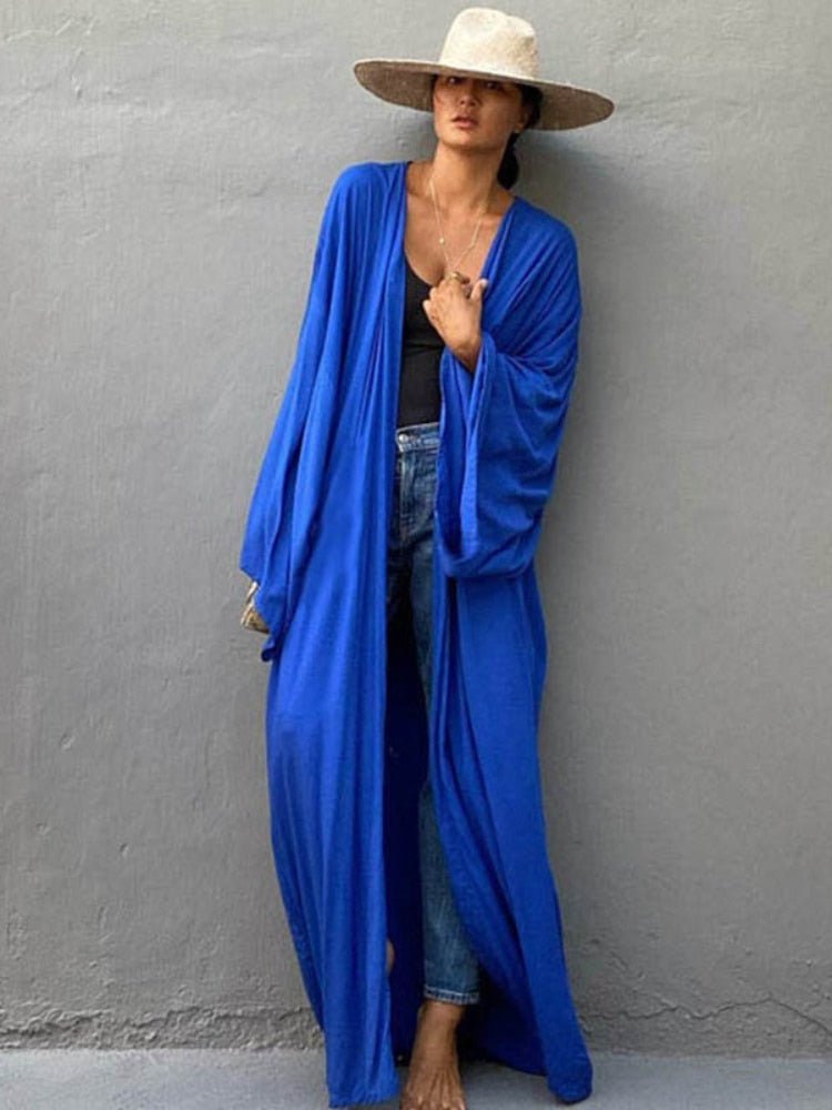 Model is wearing the royal blue Sole Kimono from Shop the Kei with jeans. A Bohemian-style ankle-length beach cover-up kimono with wide sleeves and matching waist sash, perfect for vacation, poolside, or post-swim lounging.