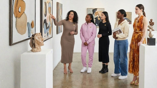 Professor discusses art to her students in a gallery. Every woman wears garments from our Autumn capsule collection. Golden Crown Essentials and Amber Jewels fashion