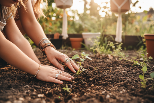 A woman and daughter reach their hands to the soil in a garden