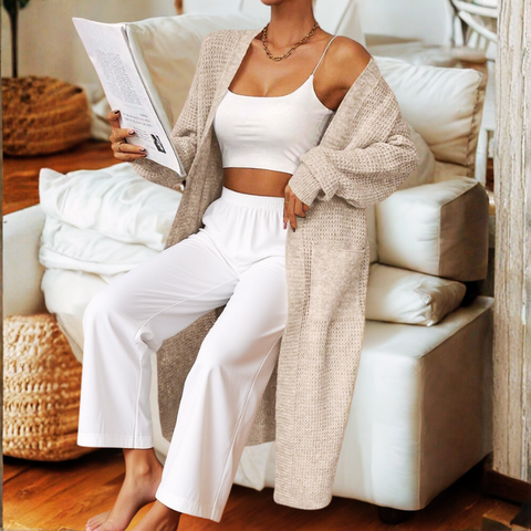 Woman reading a magazine on a white couch in a cozy living room.
