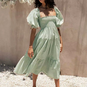 Front view of the Pixi Dress in mint green gingham pattern showcasing square neckline, voluminous puff sleeves, smocked bodice, and flowing tiered midi skirt. Dress photographed in bright sunlight against a neutral backdrop.