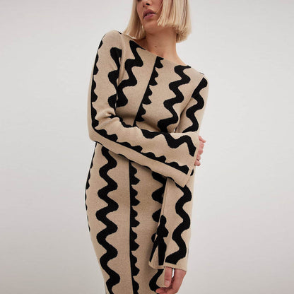 Model embraces the soft Gemini Knit Sweater Dress by ShoptheKei. Sweater dress maxi length with long flare sleeves. Body conscious. Mod 1960's style dress with vertical wavy squiggle line patterns.