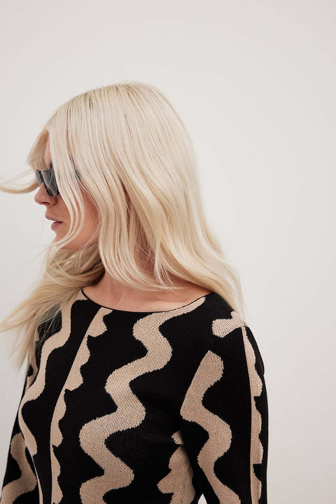 Close up of Gemini Knit Dress by ShoptheKei. Sweater dress maxi length with long flare sleeves. Body conscious. Mod 1960's style dress with vertical wavy squiggle line patterns.