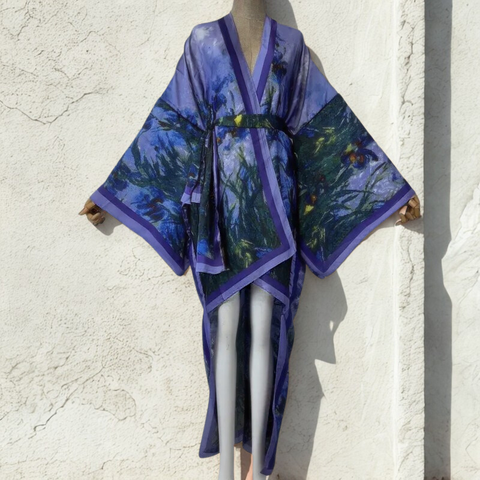 Mannequin wearing a blue and purple kimono-style garment against a light stone wall.