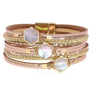Stack of gold and rose gold bracelets with gemstone accents on a white background