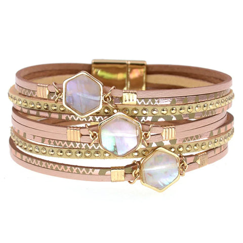 Stack of gold and rose gold bracelets with gemstone accents on a white background