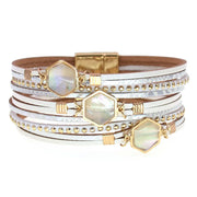 Stack of bracelets with gold and silver accents on a white background