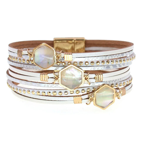 Stack of bracelets with gold and silver accents on a white background