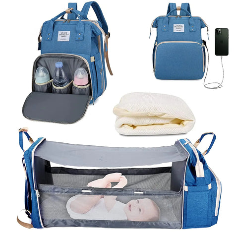 Blue baby diaper backpack shown in multiple views: with bottle storage compartment open, with USB charging port, folded mattress insert, and fully expanded as bassinet with mesh sides containing a baby. Lotus 3-in-1 bassinet diaper bag travel system with partial canopy