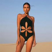 Model wearing Gabby One Piece Swimsuit in black from ShoptheKei.com. Retro-inspired tank top with halter neckline, front flower cut out, and o-ring.