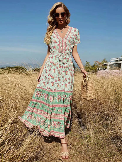 Birdie Summer Midi Dress from Shop the Kei - featuring a bohemian styled dress with flower print, v neck button closure, adjustable waist tie, soft natural textile and texture, and flounce hem. Pairs well with a straw handbag and gold jewelry