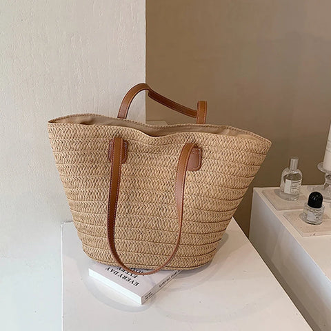 Natural tan color straw bag with tan lining, inner pocket, and brown faux leather straps 
