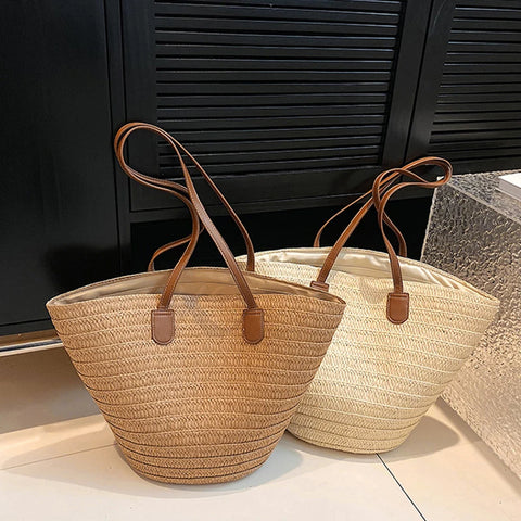 Two natural color straw bags. Bag on the left is tan and bag on the right is ivory color. Both bags have brown straps