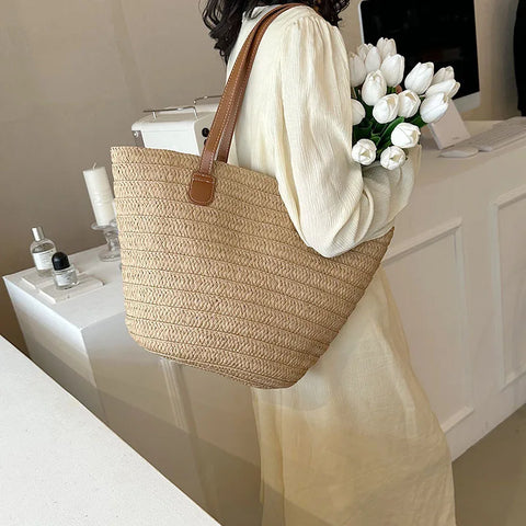 Natural tan color straw bag with tan lining, inner pocket, and brown faux leather straps 