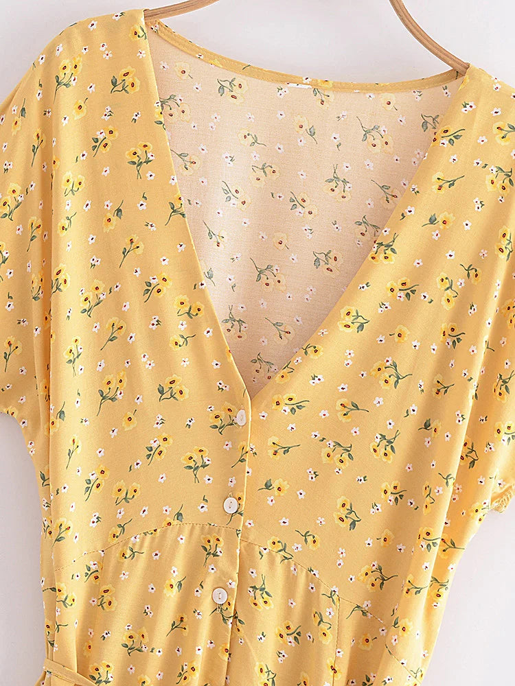 Nyla Flutter Mini Dress from Shop the Kei - close up front view of v neckline, white button closure, waist seam, yellow and white floral pattern textile