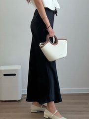 Bela Satin Maxi Skirt from Shop the Kei - side view - black bias fitting skirt. Pairs well with a straw handbag