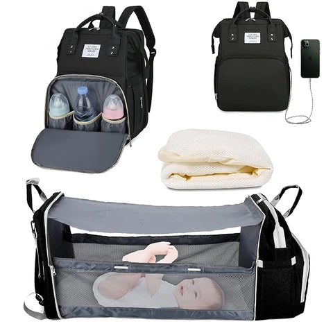 Black baby diaper backpack shown in multiple views: with bottle storage compartment open, with USB charging port, folded mattress insert, and fully expanded as bassinet with mesh sides containing a baby. Lotus 3-in-1 bassinet diaper bag travel system with partial canopy
