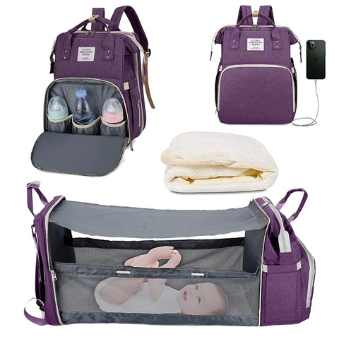 Purple baby diaper backpack shown in multiple views: with bottle storage compartment open, with USB charging port, folded mattress insert, and fully expanded as bassinet with mesh sides containing a baby. Lotus 3-in-1 bassinet diaper bag travel system with partial canopy