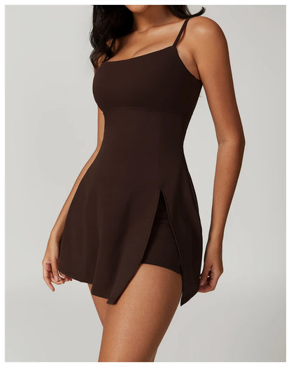 Close up view of the Bree Yoga Dress in Espresso brown color. Features thin spaghetti straps, straight neckline, fitted bodice, and A-line skirt with a pronounced side slit. Mini-length dress photographed against a neutral background.