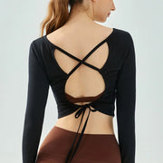 Eden Seamless Cross Back Top from Shop the Kei - classic black color option back view of soft and breathable dancer inspired long sleeve top with adjustable back straps that tie at the hem.