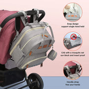 Gray Lotus 3-in-1 Bassinet Diaper Bag backpack shows different ways to carry the bag - over stroller handle, hand held, or on the ground for naps and changing