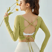 Eden Seamless Cross Back Top from Shop the Kei - light green color option back view of soft and breathable dancer inspired long sleeve top with adjustable back straps that tie at the hem.