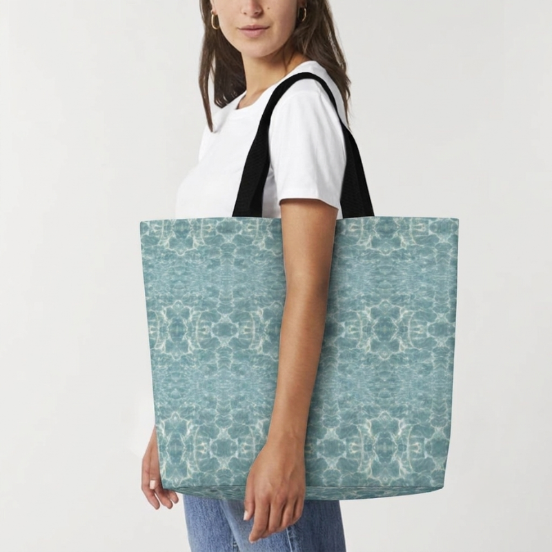 Woman carrying the Voyager tote bag in Cenote color