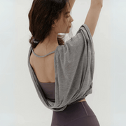 Veda Butterfly Top from Shop the Kei -  back view of the gray color option twisted hemline loose fitting dancer inspired design that drapes elegantly over the shoulders and cowls in the back.