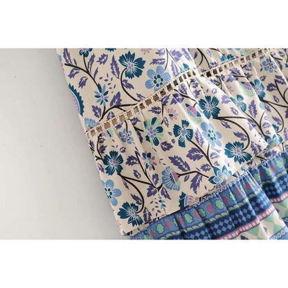 Nala Midi Dress from Shop The Kei - close up detail of in seam lace above the ruffle, 
 coordinating border print flounce gathers, and blue and purple floral boho print colors and natural textile textures.