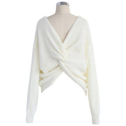 Close-up of the Aries Sweater in milk white featuring a distinctive twisted front knot design. Chunky sweater photographed on a mannequin with a white background